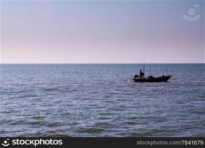 The silhouette of a fisherman with his boat in the sea