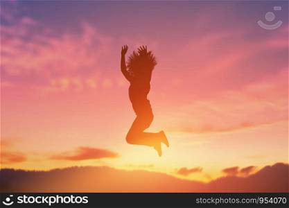 The silhouette of a happy jumping girl in a beautiful sunset