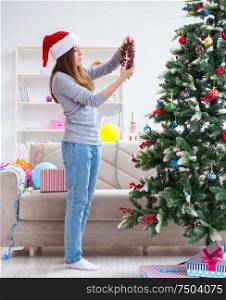 The single girl decorating christmas tree. Single girl decorating christmas tree