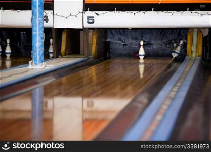 The single middle pin remains standing in a retro five pin bowling alley.