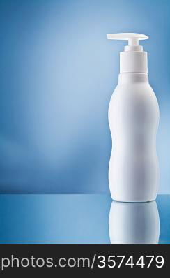 the single white bottle of cream on blue background