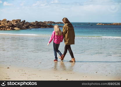 the sisters walking on the shore of the sea at the Tregastel, Brittany. France