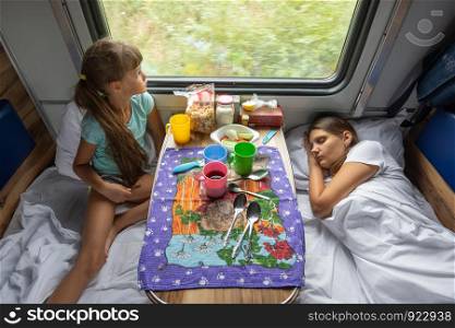 The situation on the train, mom is sleeping, daughter is looking out the window, top view