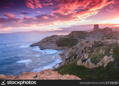 The sky lights up purple and pink behind the Genoese tower at Ile Rousse, looking out to sea over Cap Corse in the Balagne region of Corsica