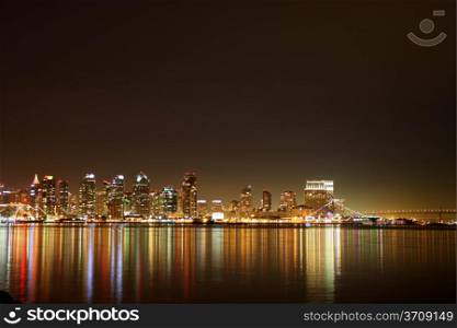 The skyline of San Diego at night with reflection in the water.