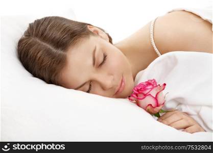 The sleeping young woman holds a rose in a hand, isolated