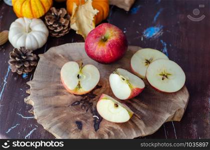 The sliced and whole apples, mini pumpkins, autumn concept on wooden table