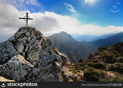 The small cross and cairn at the top of Capu di a Veta behind the citadel town of Calvi in the Balagne region of Corsica