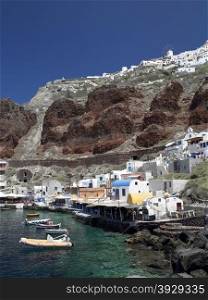 The small harbor below the clifftop town of Oia on the Greek Island of Santorini (Thera) in the Cyclades group in the Aegean Sea.