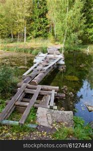 The small shabby bridge in park over a pond