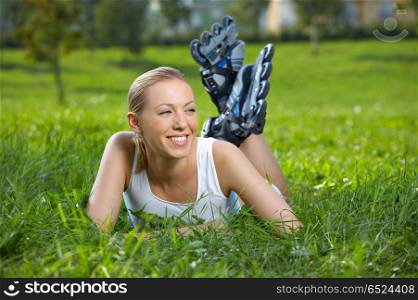 The smiling blonde in rollers lies on a lawn. Sports rest