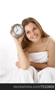 The smiling young woman with an alarm clock, isolated