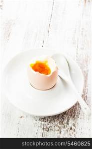 The soft-boiled egg in an eggcup with spoon