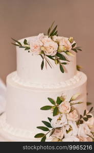 The solemn moment of serving a delicate wedding cake at a Banquet.. Beautiful and delicate design of a wedding cake for the bride and groom 2674.