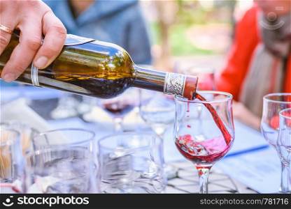 the sommelier spills wine in glasses on wine tasting on open ar. the sommelier spills wine in glasses on wine tasting