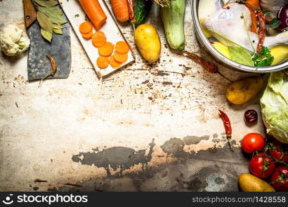 The soup of chicken, vegetables and spices. On rustic background .. The soup of chicken, vegetables and spices.