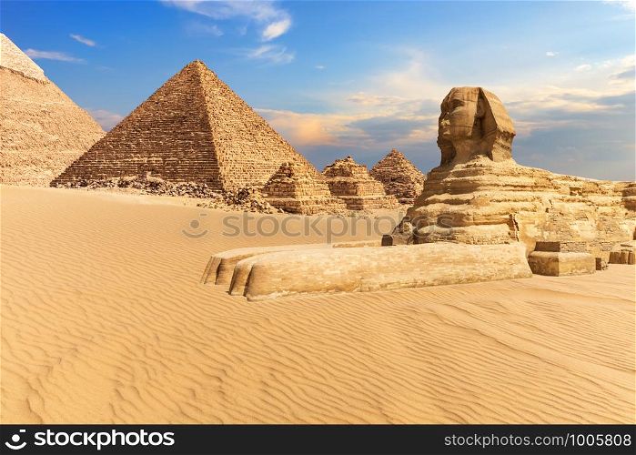 The Sphinx of Giza next to the Pyramids in the desert, Egypt.. The Sphinx of Giza next to the Pyramids in the desert, Egypt