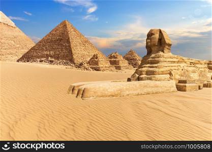 The Sphinx of Giza next to the Pyramids in the desert, Egypt.. The Sphinx of Giza next to the Pyramids in the desert, Egypt