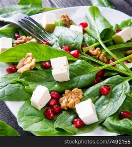 The spinach salad with nuts and apples served on table. Spinach salad with nuts and apples served on table