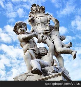 The statue of angels with embleb od the city on Square of Miracles in Pisa near Leaning Tower, Italy