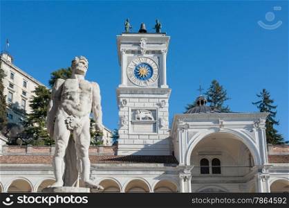 The statue of Hercules(17th century) in the background with the clock tower of the colonnade of St. John .At Liberty Square, Udine Italy