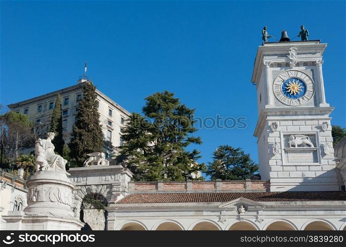 The statue of Peace with the clock tower of chiesa.In Freedom Square, Udine Italy