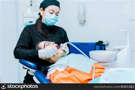 The stomatologist cleaning a patient&rsquo;s teeth, a dentist cleaning a patient&rsquo;s mouth, a dentist cleaning a patient&rsquo;s caries, a dentist cleaning a patient&rsquo;s mouth