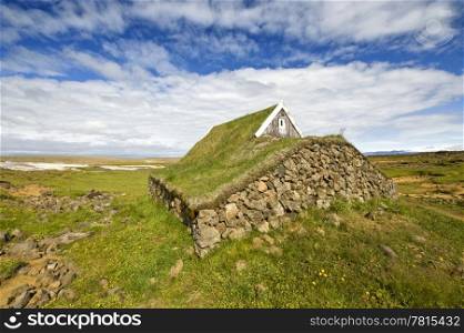 The stone walls, and grass covered roof for insulation purposes of an old, traditionally build cabin in Hveravallir, Iceland