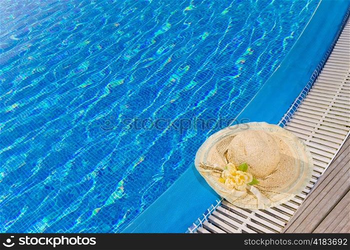 The straw hat lies on the brink of pool