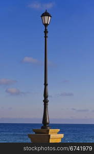 the street lamp against the background of sea and blue sky