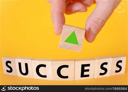 The success of the text on a yellow background of wooden cubes. business growth in teamwork.. The success of the text on a yellow background of wooden cubes.