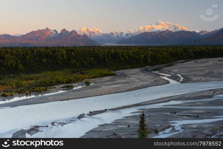 The sun rise glows as it hits the tall peaks in the Denali Mountain Range