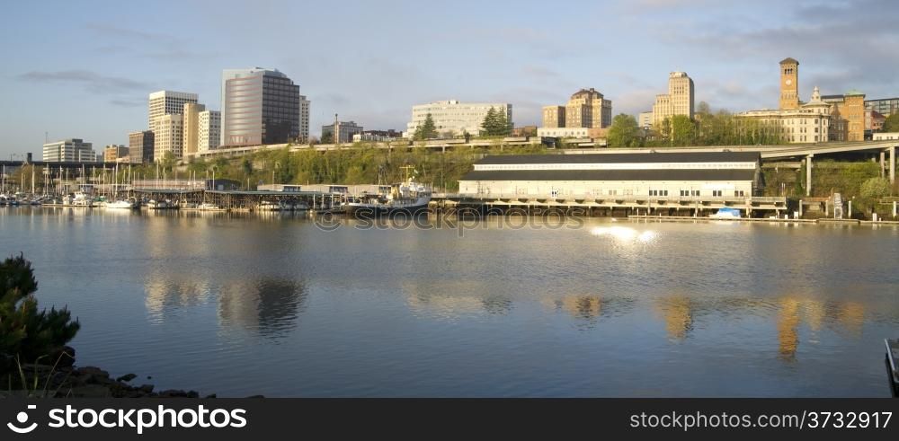 The sun rises hitting the waterfront and buildings of Downtown Tacoma Washington United States