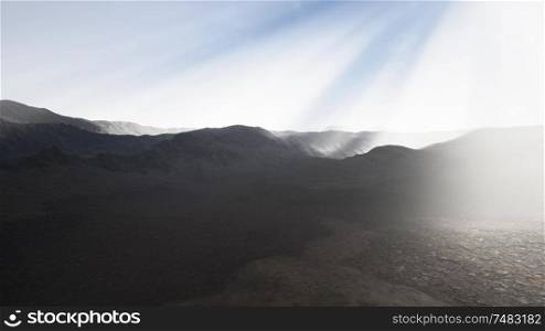 the sun&rsquo;s rays against the backdrop of the mountains and the lava-rocky wet shore in the foreground. Sun Rays against the Backdrop of the Mountains