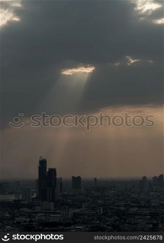 The sun&rsquo;s rays passing through the clouds and illuminate skhining down over the skyscraper of bangkok. Hole lighting selecting.