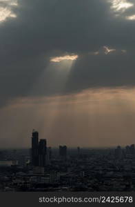 The sun&rsquo;s rays passing through the clouds and illuminate skhining down over the skyscraper of bangkok. Hole lighting selecting.