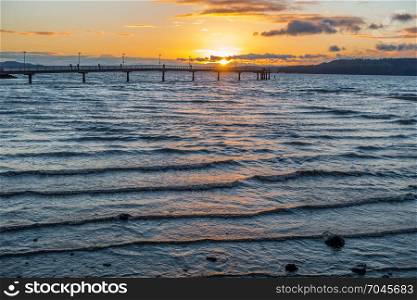 The sun sets behind the fishing pier in Des Moines, Washington.