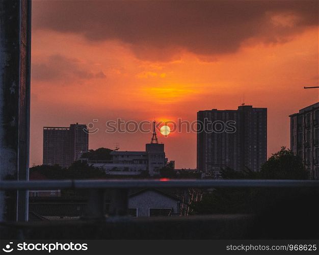 The sun setting in city over buildings during sunset time