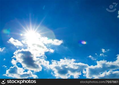 The sun shines bright in the daytime in summer. Blue sky and clouds.