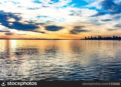 The sun went over the horizon of the Amur river in the city of Khabarovsk, forming magnificent colors in the sky. Beautiful colors in the sky, which are reflected in the water.. Beautiful sunset from the waterfront near the arena Erofey city of Khabarovsk.