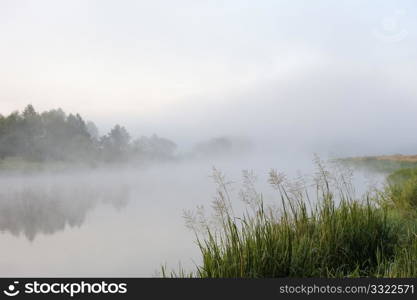 The sunrise, over the river rises a morning fog.