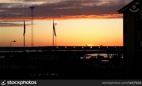 The sunset over Visby harbor in Gotland in Sweden in May. The sunset over Visby harbor in Gotland in Sweden