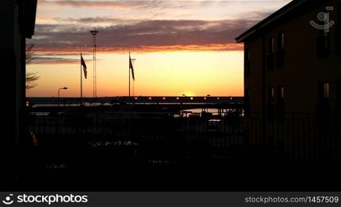 The sunset over Visby harbor in Gotland in Sweden in May. The sunset over Visby harbor in Gotland in Sweden