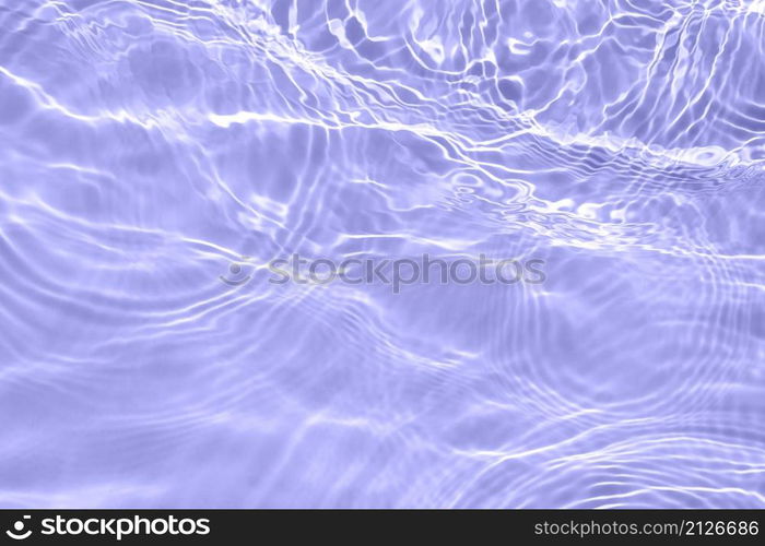 The surface of light on the purple transparent swimming pool water. Abstract wavy background. Water waves in sunlight banner. Trendy banner with 2022 color of the year very peri.