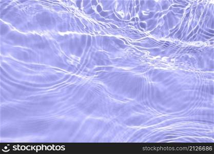 The surface of light on the purple transparent swimming pool water. Abstract wavy background. Water waves in sunlight banner. Trendy banner with 2022 color of the year very peri.