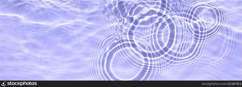 The surface of light on the purple transparent swimming pool water. Abstract wavy background. Water waves in sunlight banner. Long Trendy banner with 2022 color of the year very peri. The surface of light on the purple transparent swimming pool water. Abstract wavy background. Water waves in sunlight banner. Long Trendy banner with 2022 color of the year very peri.