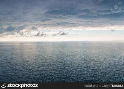 The surface of the sea with a slight ripple, a view of the horizon and heavy black rain clouds a beautiful landscape