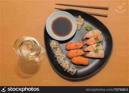 The sushi meal with a glass of white wine is ready