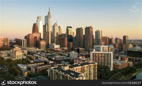 The tall buildings reflect saturated sunset light in the glass in this downtown metro philly area aerial