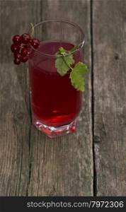 the tall glass of juice decorated with a red branch of currant, a subject drinks and berries
